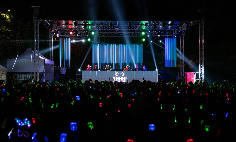 Escenario con luces y público con auriculares en un evento de empresa